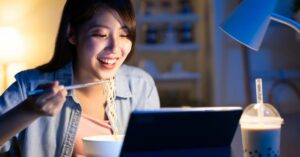 Craving Comfort Food? Discover the Best Instant Ramen 2 (woman enjoying ramen at her computer)