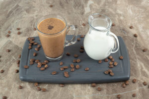 Bottled Condensed Milk: A Sweet Touch to Vietnamese Coffee and Desserts 2 Glass of Vietnamese cà phê sữa đá with dark coffee and thick condensed milk layer on a dark plate.