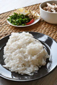 Flat Rice Noodles for Pho: Why Shape and Texture Matter 2 Fresh rice noodles on a plate.